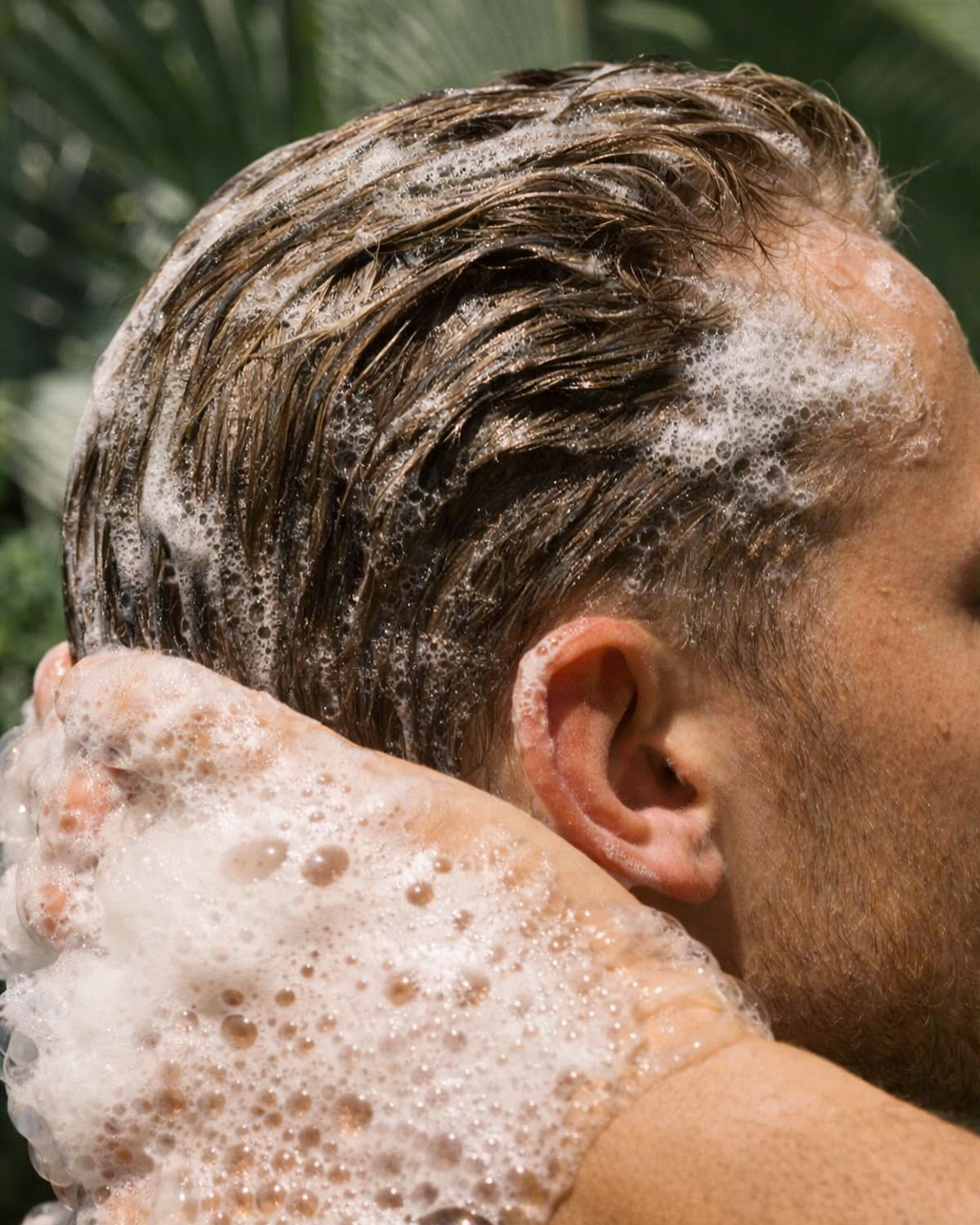 Man tvättar håret utomhus